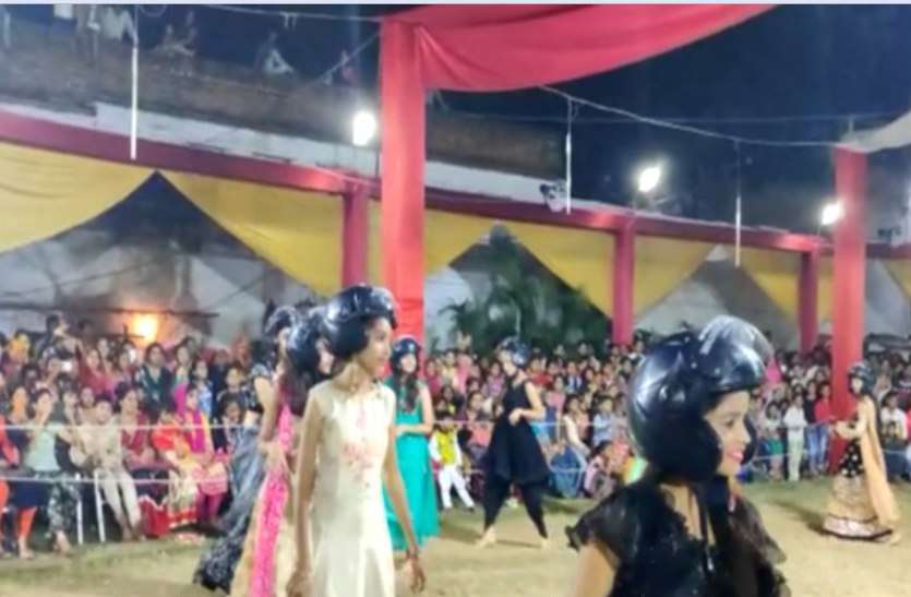 young couple perform garba in datia with wearing helmet
