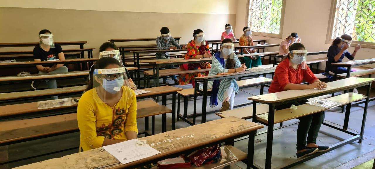 मास्क पहनकर सोशल डिस्टेंस के साथ आज अहमदाबाद के अंबाबाड़ी के निकट की सीएन विद्यालय में आईआईटी का एग्जाम परीक्षा देते विद्यार्थी