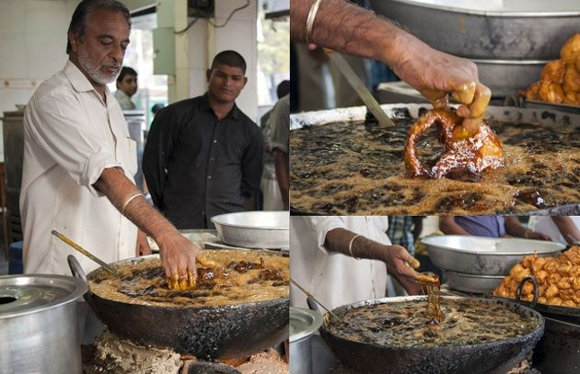 indian chef fries fish in boiled oil