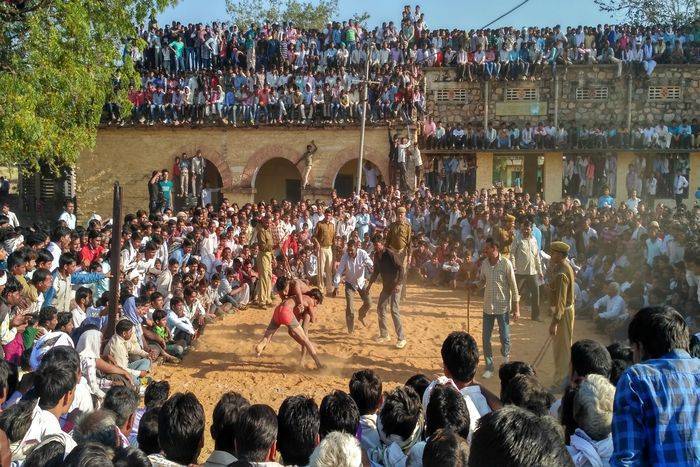 People climbed onto the roofs and the trees watching wrestling