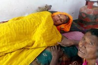 मन्दिर में लेटी वृद्धा।