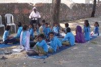 खुले में बैठे विद्यार्थी