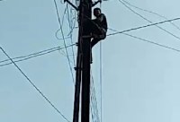 Young man climbed on electric pole