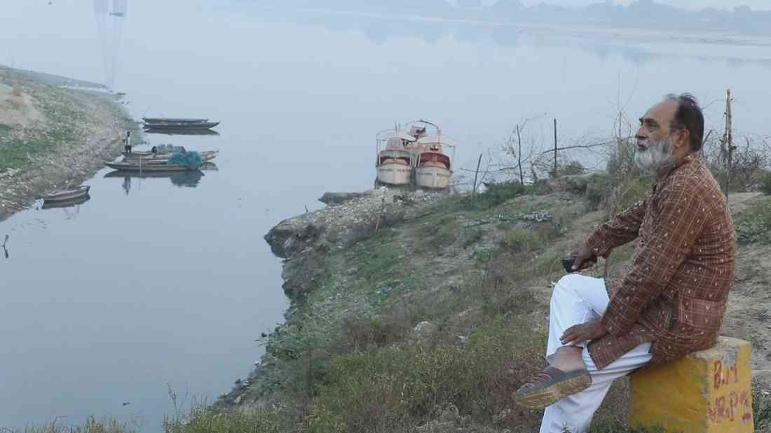 कलाकार हरीश द्विवेदी काशी की प्रदूषित हो चली गंगा को अपलक निहारते
