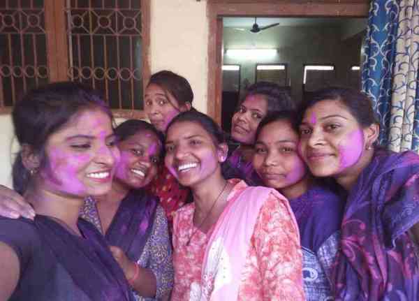 चेहरे पर कलर लगाने के बाद सेल्फी लेतीं छात्राएं