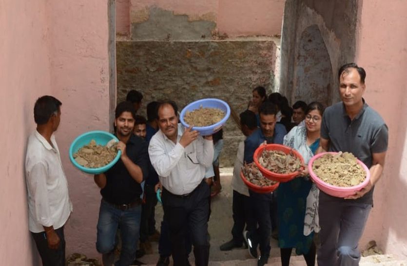 श्रमदान करते अधिकारी।