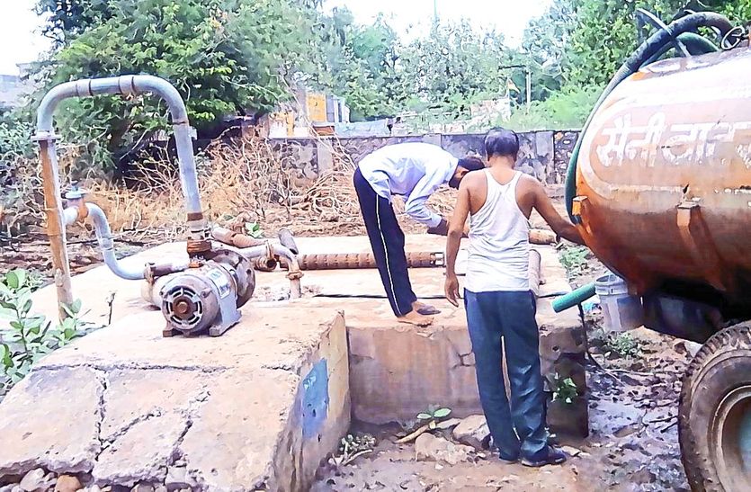 टैंकरों से टंकी भरते कार्मिक।