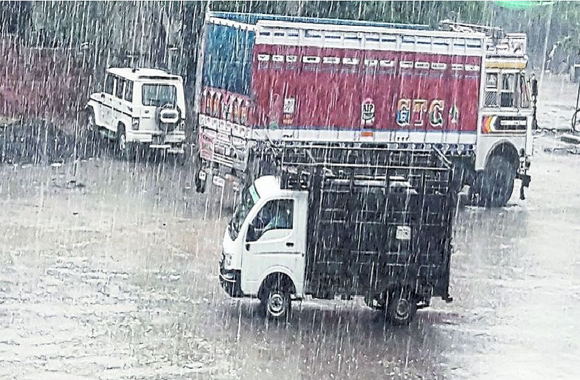 मण्डी रोड पर बारिश में गुजरते वाहन।
