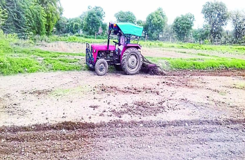 एक खेत में जुताई करता किसान।