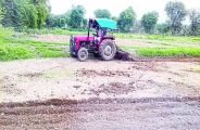  एक खेत में जुताई करता किसान।