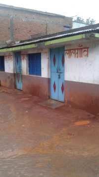 school of MP: campus filled water, students sit and read in teen shed