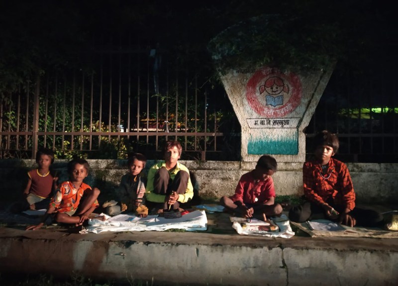 Children read in street light