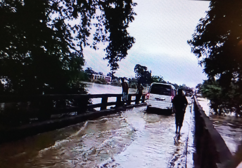 पुल के ऊपर से बह रहा बाढ़ का पानी और जान जोखिम में डाल लोग पार कर रहे वाहन- देखें Video