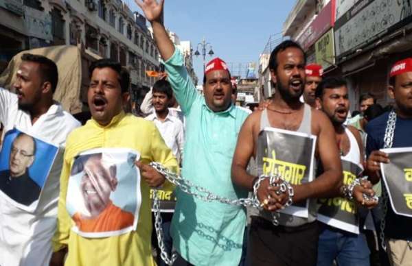 सपा कार्यकर्ताओं ने खुद को जंजीर से जकड़ कर केन्द्र की नीतियों का विरोध किया