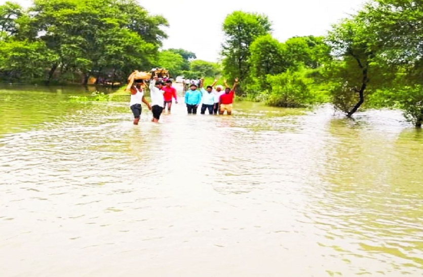 पानी में होकर निकलते लोग।