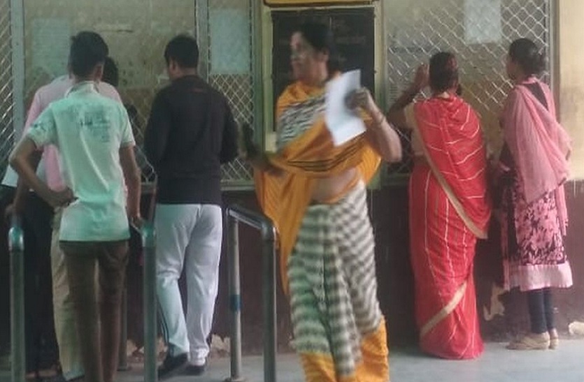 काउन्टर पर पर्ची कटाते रोगी।