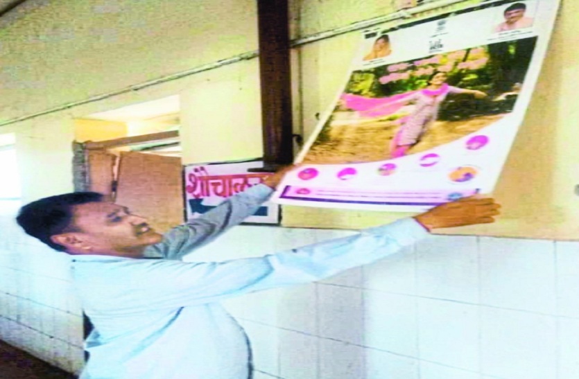 लगे पोस्टर हटाते कार्मिक।