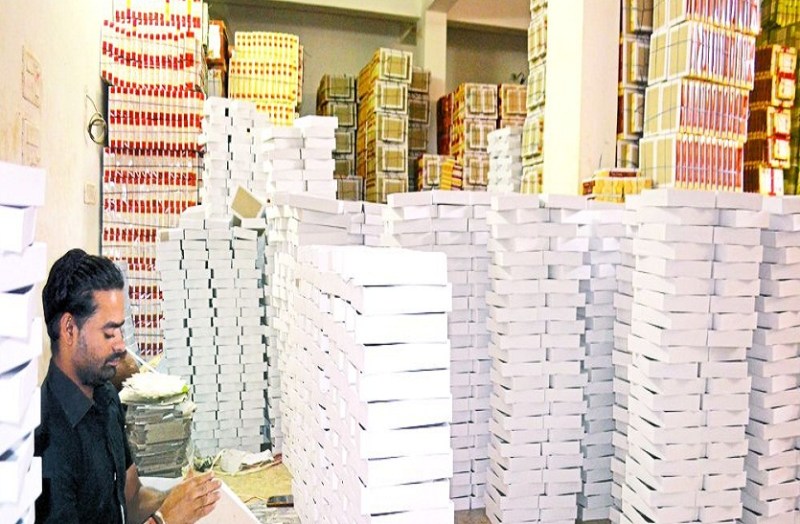 डिब्बे बनाने में जुटा कार्मिक।