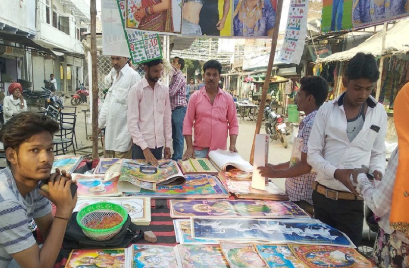 कलेंडर खरीदते लोग।