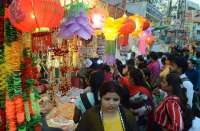 वाराणसी के चेतगंज इलाके में सजी दुकानों से लैम्प, झालर व सजावटी सामान की खरीदारी करती महिलाएं