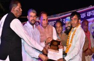 छात्र को सम्मानित करते अतिथि।