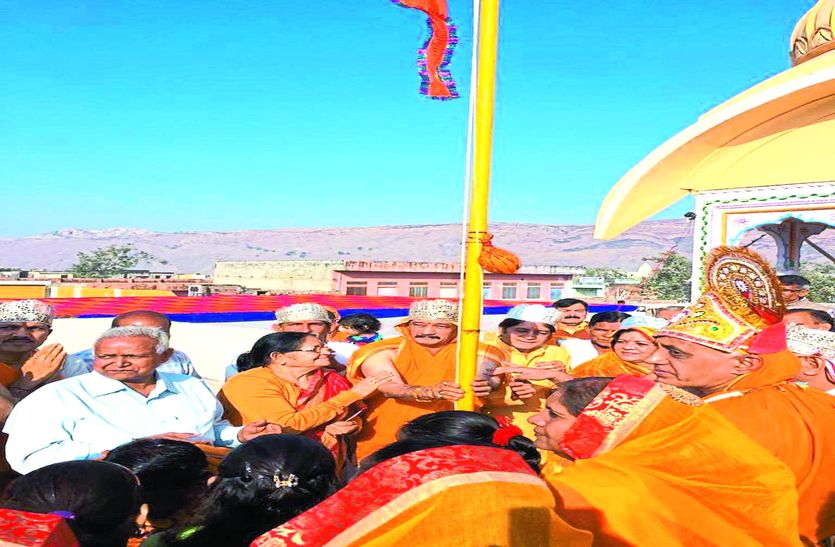ध्वजारोहण करते श्रद्धालु।