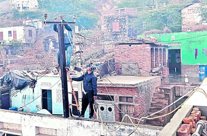 टूटे तार को जोड़ते निगम कर्मचारी।