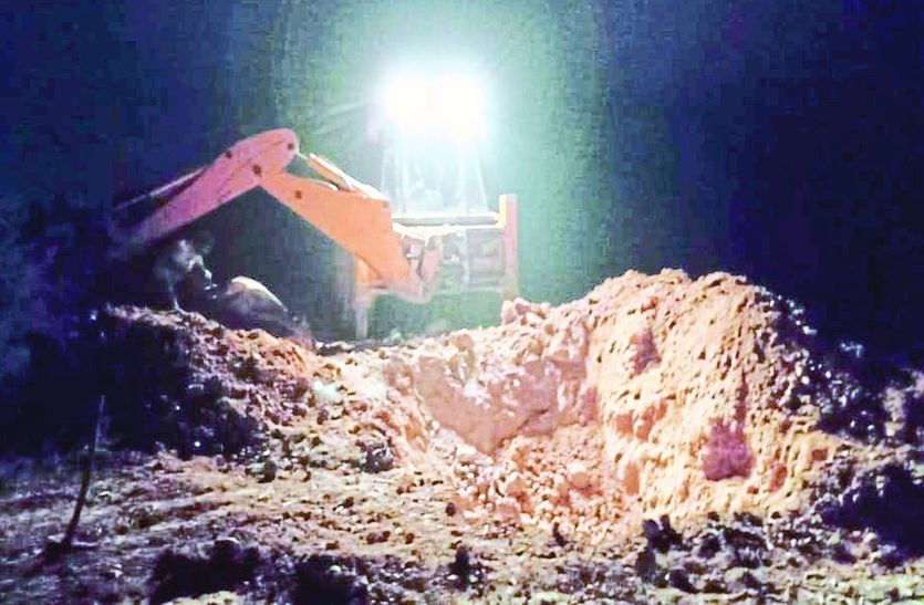 दफनाने के लिए गड््ढा खोदती जेसीबी मशीन।