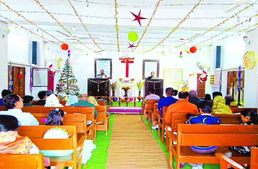 सजावट व चर्च में प्रार्थना करते लोग।