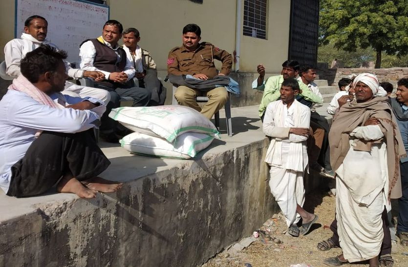 पुलिस की मौजूदगी में किया जा रहा खाद वितरण।