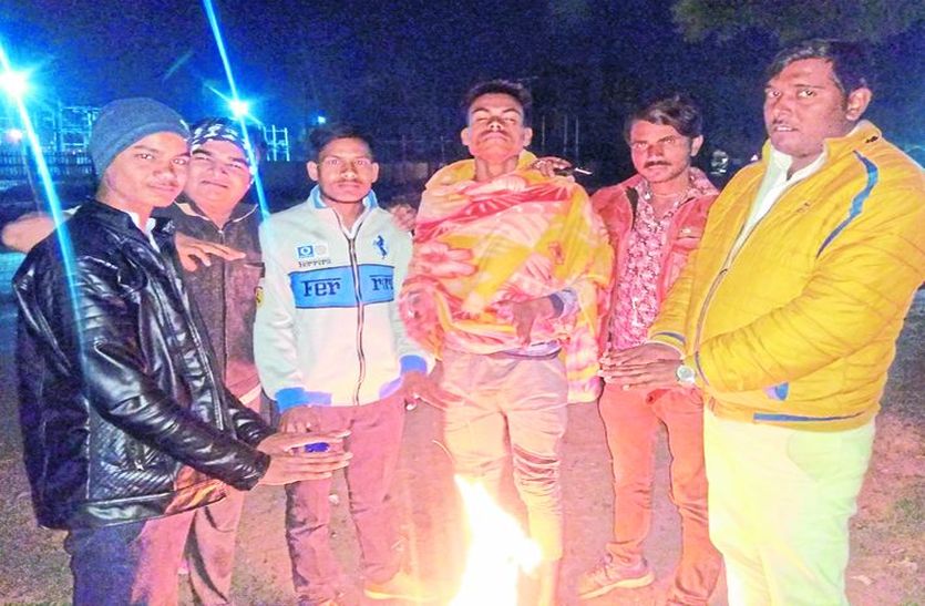 सर्दी से बचाव के लिए अलाव तापते लोग।