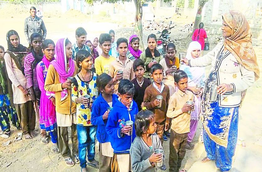 स्कूल में दूध के लिए कतार में खड़े बच्चे।
