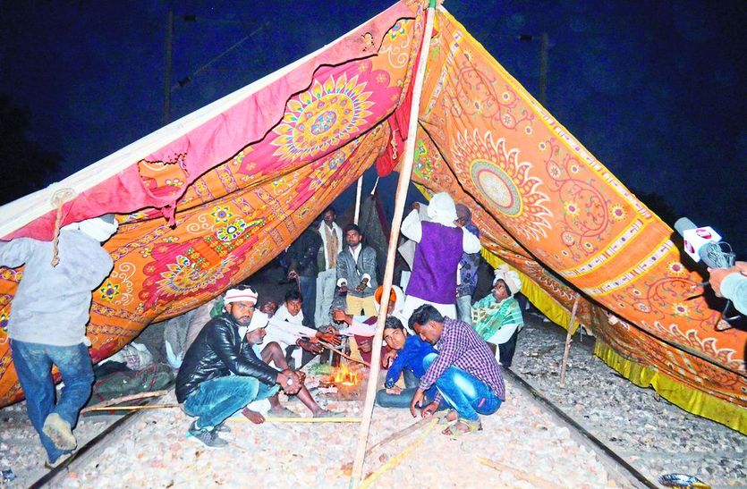 ट्रेक पर शनिवार देर रात को अलाव तापते आंदोलनकारी।