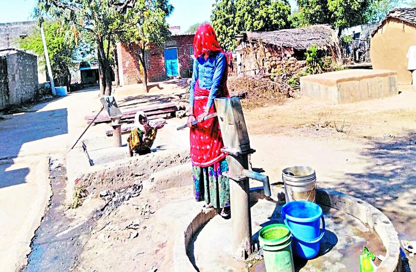 खाली बर्तन लेकर खड़ी महिला।