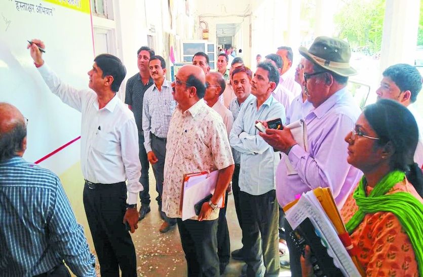 हस्ताक्षर करते हुए जिला निर्वाचन अधिकारी।