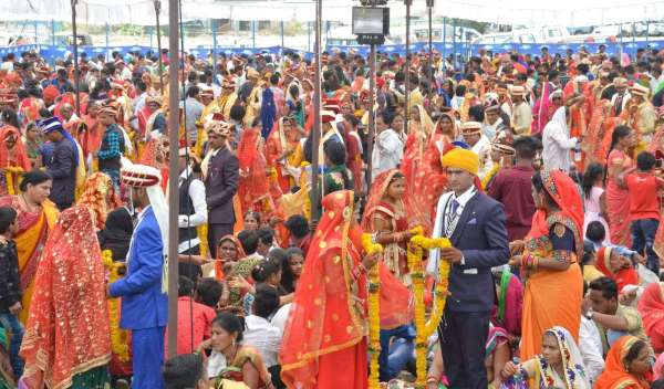 सामूहिक विवाह में वरमाला पहनाते दूल्हा दुलहन