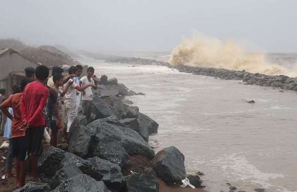 गुजरातः समुद्री किनारे पर वायु चक्रवात से पहले बिगड़ते मौसम के बाद समुद्र का रौद्र रूप देखते लोग