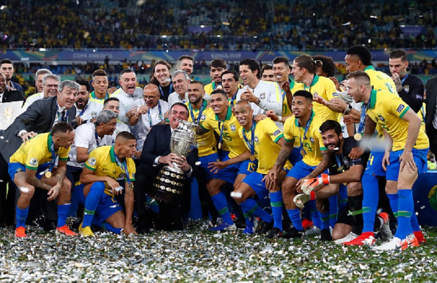 President of Brazil Jair Bolsonaro and players of Brazil pose with the trophy after winning the Copa America 2019