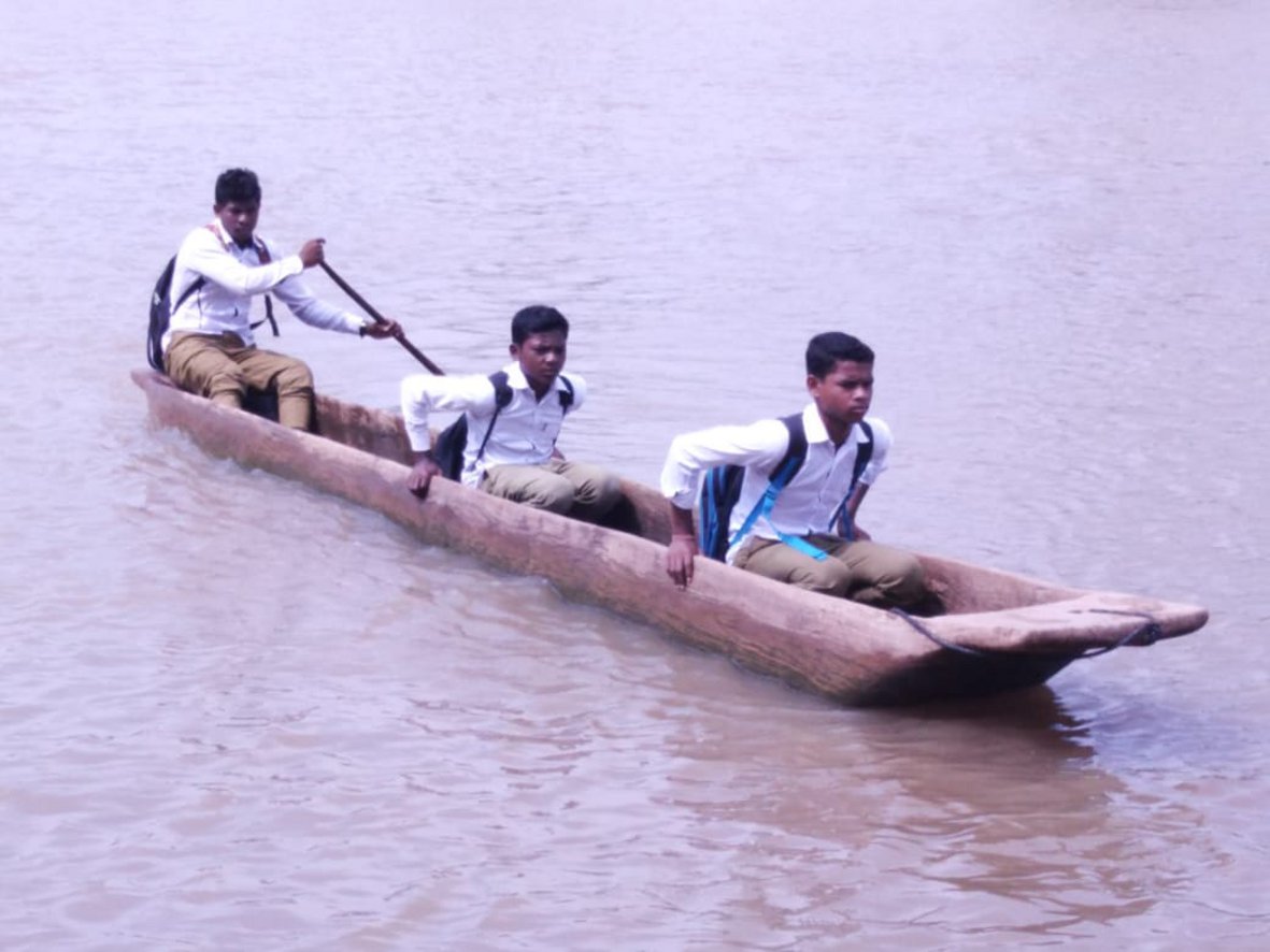 Students cross river in a wooden canoe to read
