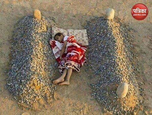 Syrian boy sleeping between the graves of his parents