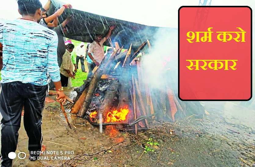 viral video of burning pyre in heavy rain covered by plastic