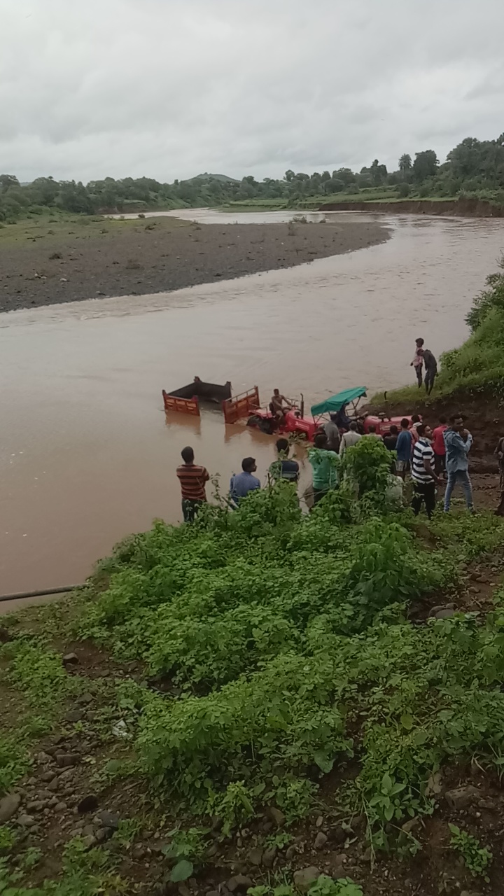 Tractor-trolleys stuck in the river