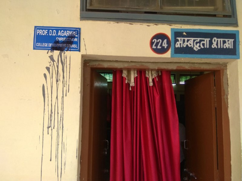 कुलसचिव और डीसीडीसी की नाम पट्टिकाओं पर पोती कालिख