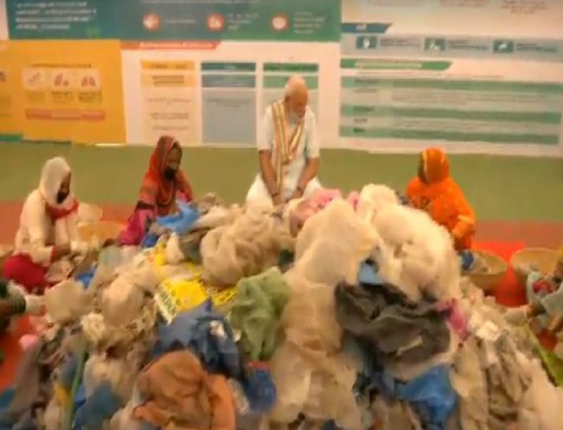 PM Modi LIVE:कचरा से प्लास्टिक बीनने वाली महिलाओं के बीच चप्पल उतारकर बैठे प्रधानमंत्री