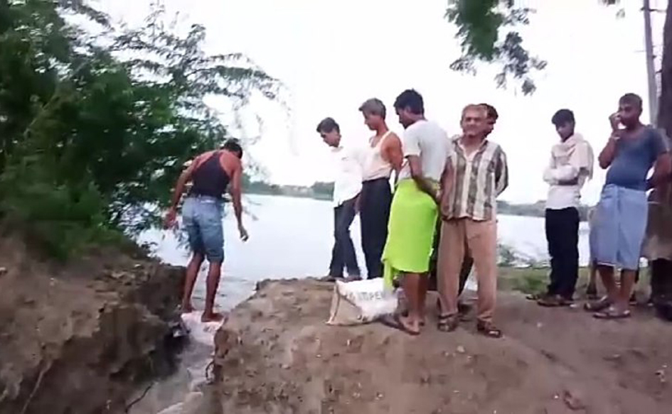 ग्रामीणों के सहयोग से मिट्टी के कट्टे डालकर तालाब के रिसाव को रोका