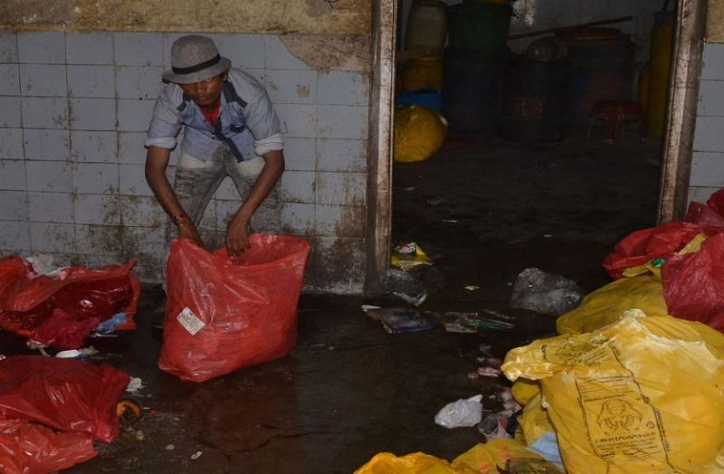 नंगे हाथ, बिना मास्क थैलियों से निकाल रहे खून से सना कचरा