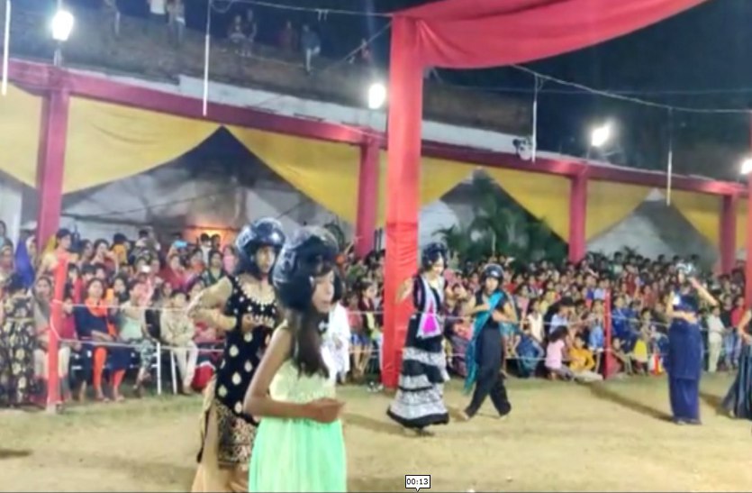 young couple perform garba in datia with wearing helmet