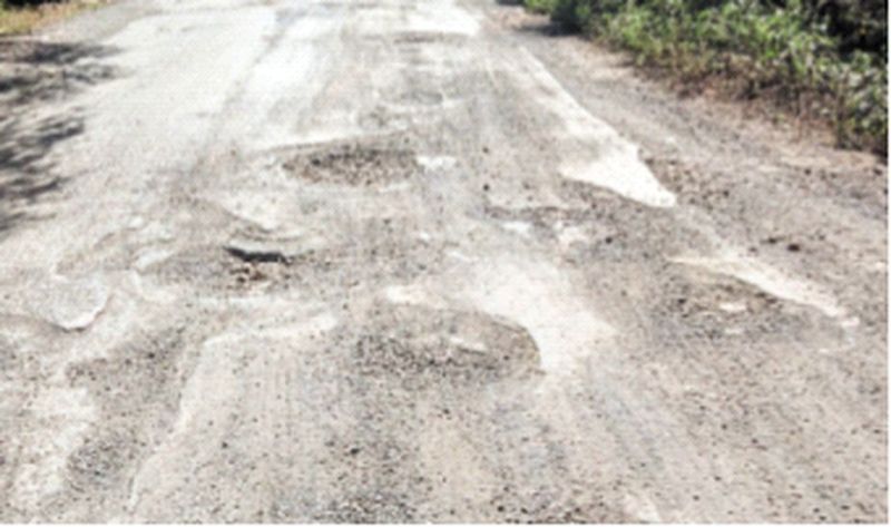 इन गड्ढों भरे रास्ते से गुजर रहे पर्यटक