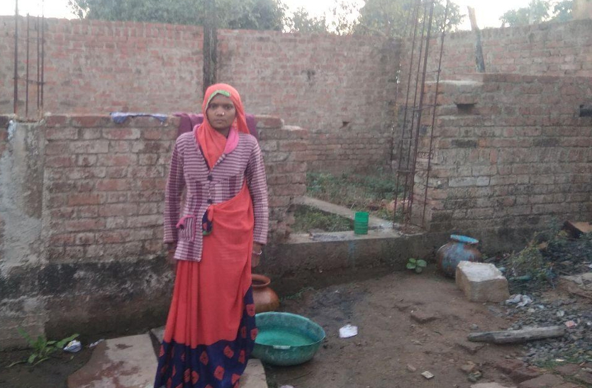 Shakun, wife of Sandeep, a tribal youth standing in front of incomplete PM house.
