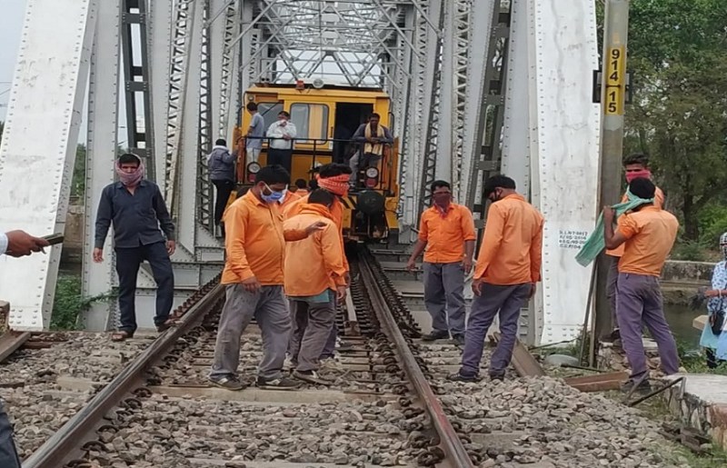 ट्रेक मशीन पर समूह में काम कर रहे रेलकर्मी